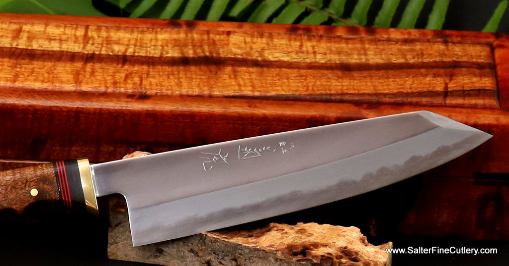 Mirror polish chef knife shadowed detail view showing bladesmith kanji exclusively from Salter Fine Cutlery with presentation box and matching curly koa wood handle