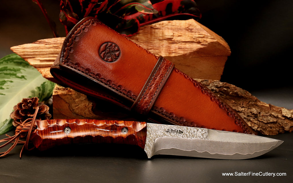 Hunting Knife with logo sheath and decorative hand-tooled sheath strap featuring 155mm Raptor design series R2 stainless steel beveled hand-forged Japanese blade and scalloped curly koa handle from Salter Fine Cutlery of Hawaii